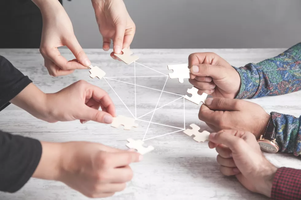 hands-people-holding-jigsaw-puzzle-connection-partnership-success-teamwork
